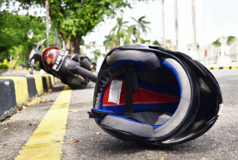 Image is of a motorcycle laying on it's side on the road and a helmet on the ground, concept of what to do following a hit and run motorcycle accident in Nashville