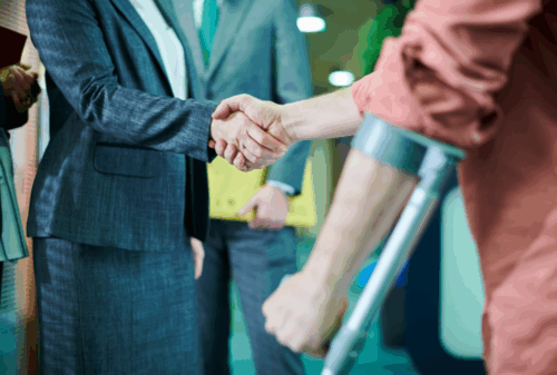 Image is of a man using a cane shaking hands with a lawyer, concept of filing a lawsuit for faulty airbags