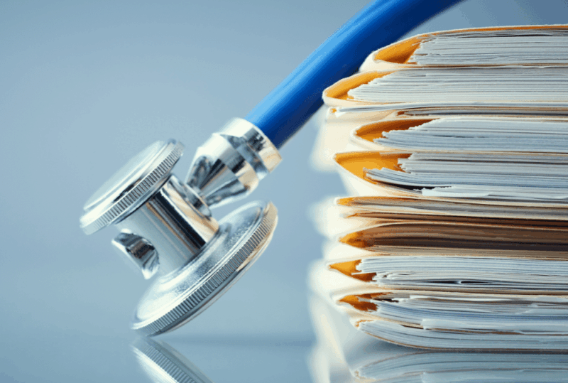 Image is of a stethoscope over a stack of medical records in manilla folders, concept of why medical records matter in a Nashville personal injury case