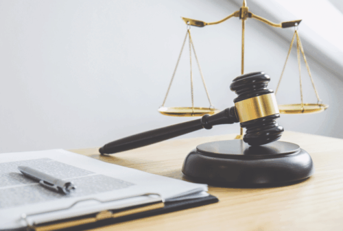 Image is of papers on a desk next to a judge's gavel and scales of justice, concept of why medical records matter in a Nashville personal injury case