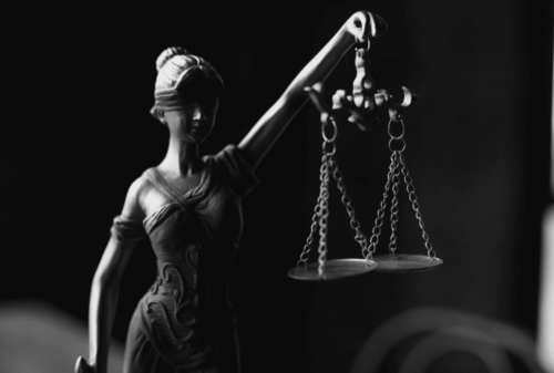 Image is of a closeup of a statuette of Lady Justice in black and white, concept of common causes for semi-truck crashes in Nashville