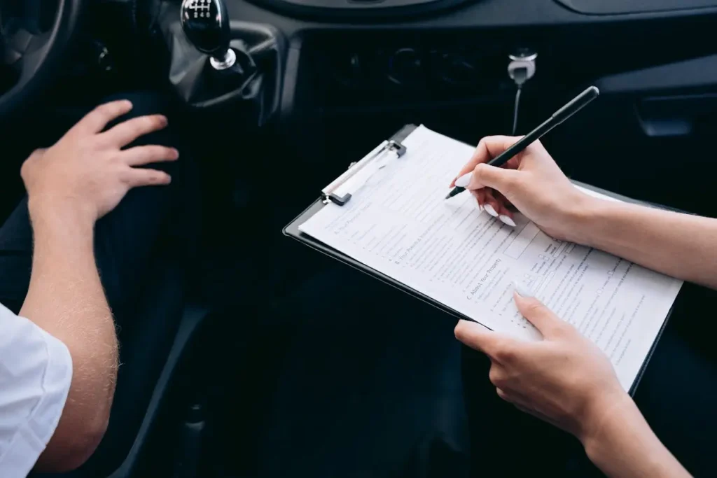 Driver completing accident report paperwork after a car accident.