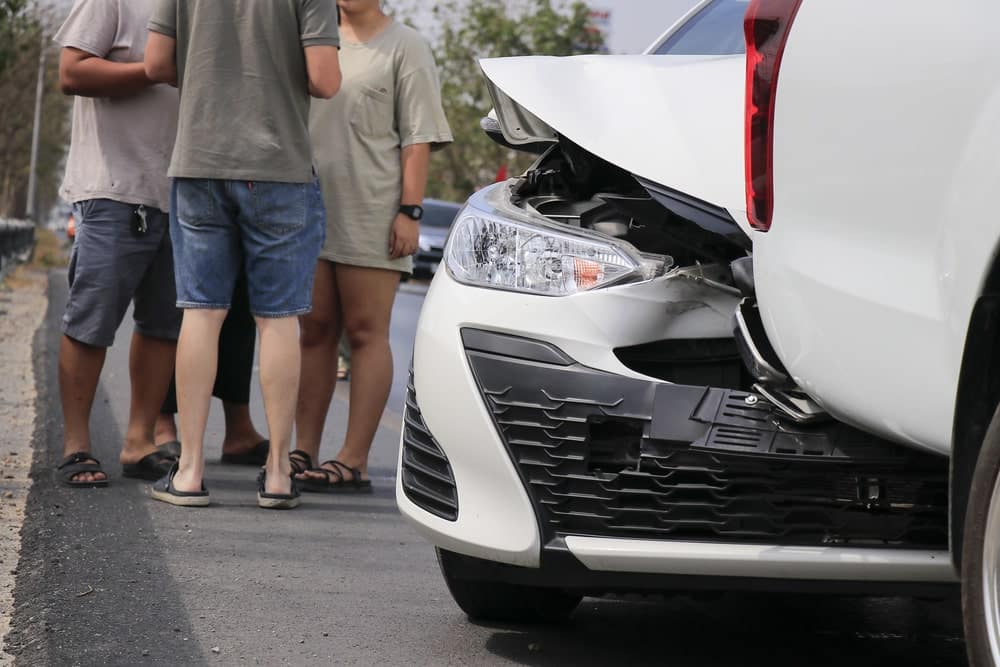 Damaged white car and people talking after a car accident in Nashville