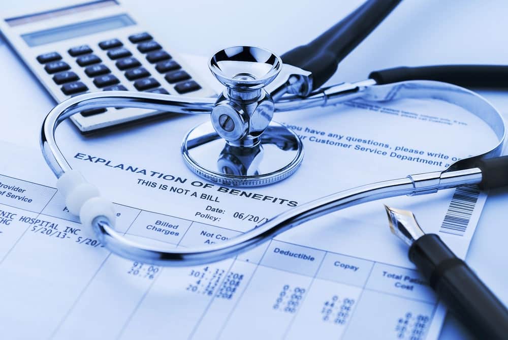 mage shows a stethoscope on a hospital billing statement with a calculator symbolizing insurance claims and medical bill processing