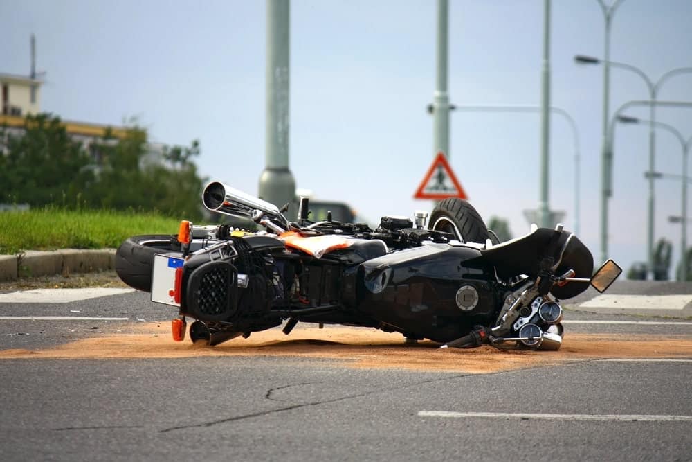Image is of a motorcycle overturned at an intersection with traffic signage visible, highlighting intersection hazards linked to motorcycle accidents in Nashville