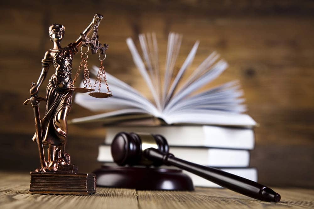 Image is of scales of justice beside law books and a gavel, representing the legal framework courts use when applying Tennessee’s comparative fault law to car accident claims.