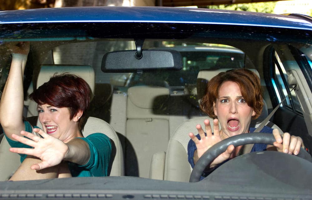 Image is of two passengers reacting in fear inside a moving car, illustrating a car crash in Nashville and potential injury claims