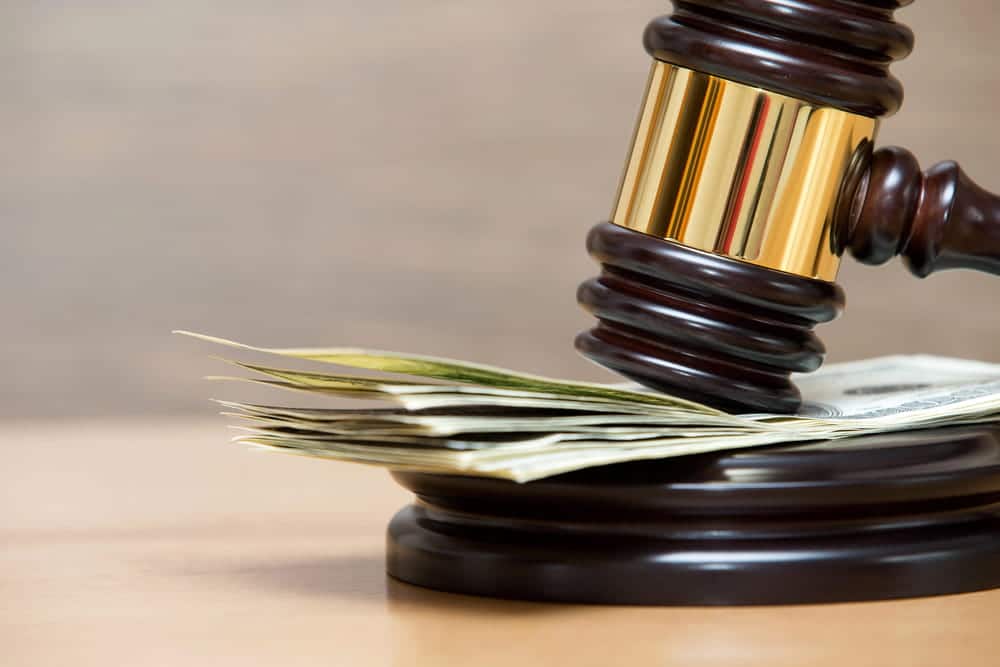 Image is of a judge’s gavel resting on cash, symbolizing financial compensation involved in a truck accident settlement case.