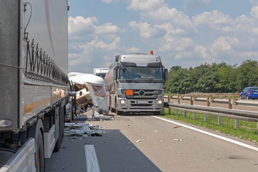 Image is of a commercial truck involved in a highway collision, illustrating the type of serious crash that can lead to a truck accident settlement claim.