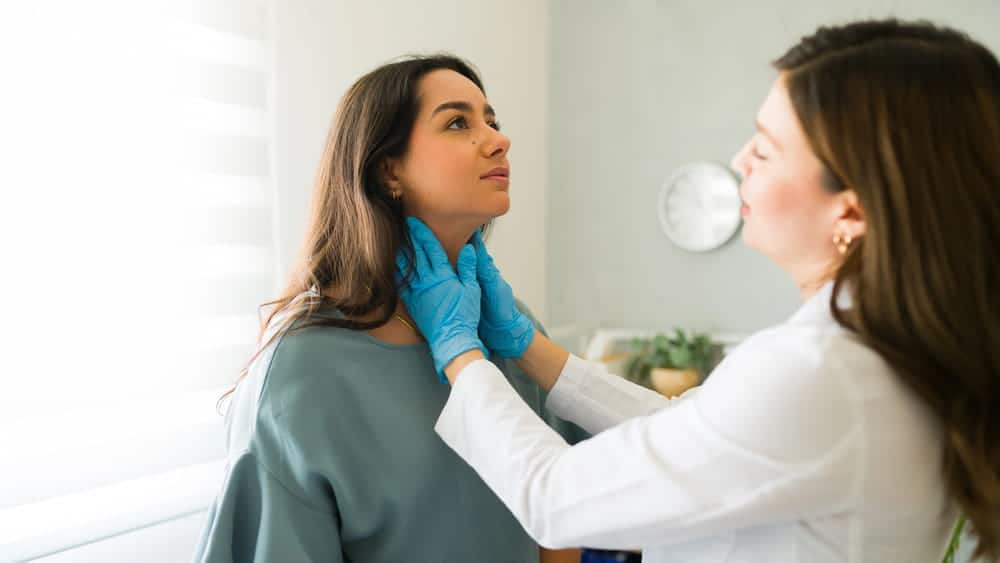 Image is of a medical professional examining a woman’s neck, representing delayed injury symptoms after a car accident in Nashville.