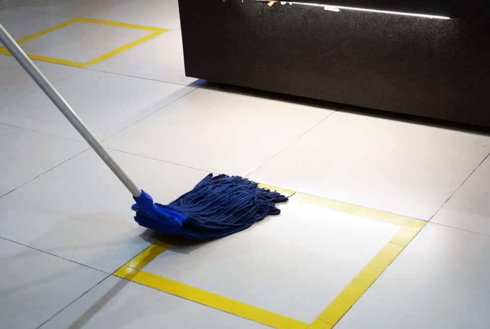 Image is of a worker mopping a tiled floor inside a restaurant, representing a potential hazard related to a slip and fall in Nashville.