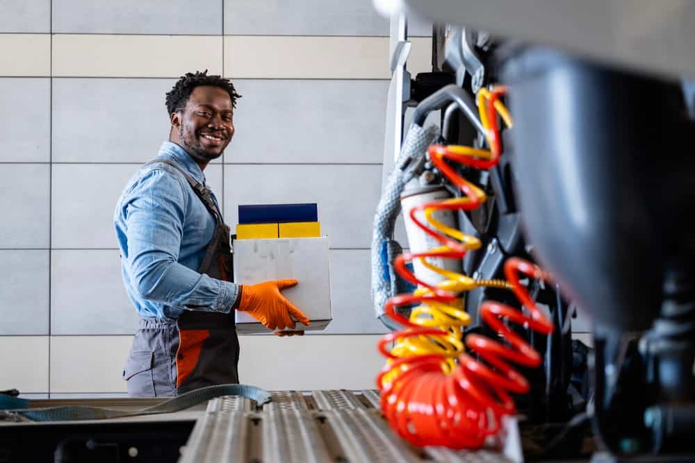 Image is of a mechanic holding equipment in a workshop, highlighting maintenance issues linked to truck accidents in Nashville