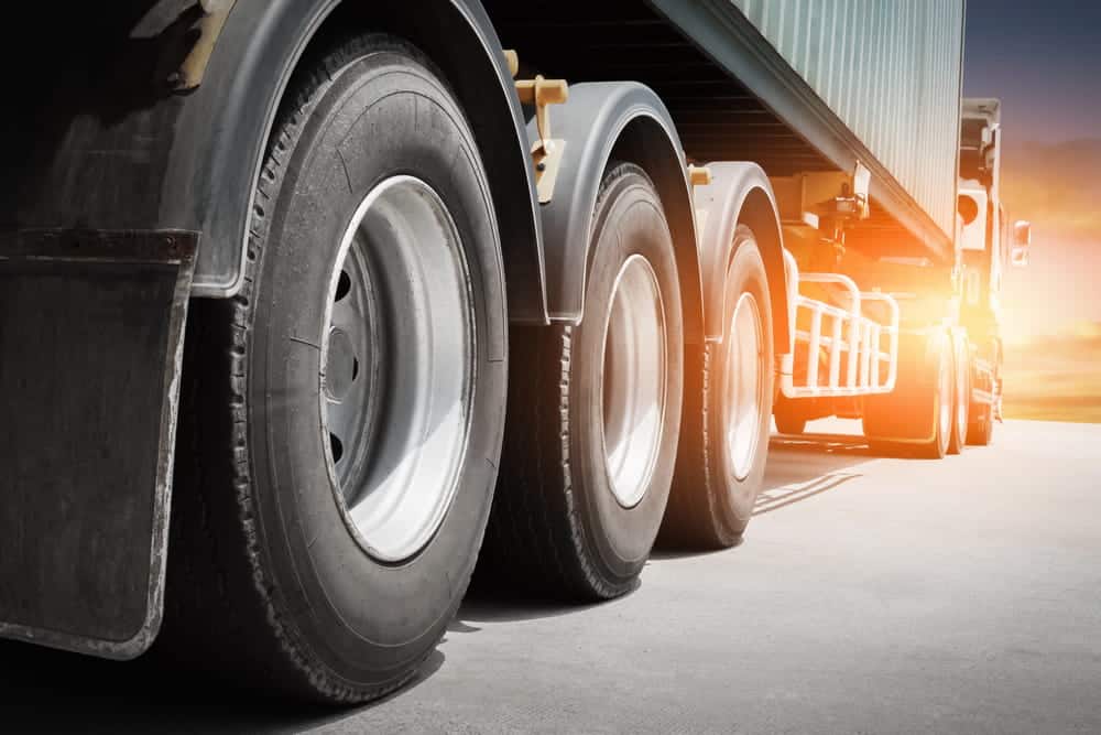 Image is of a close view of semi truck wheels on the road, concept of poor upkeep leading to truck accidents in Nashville