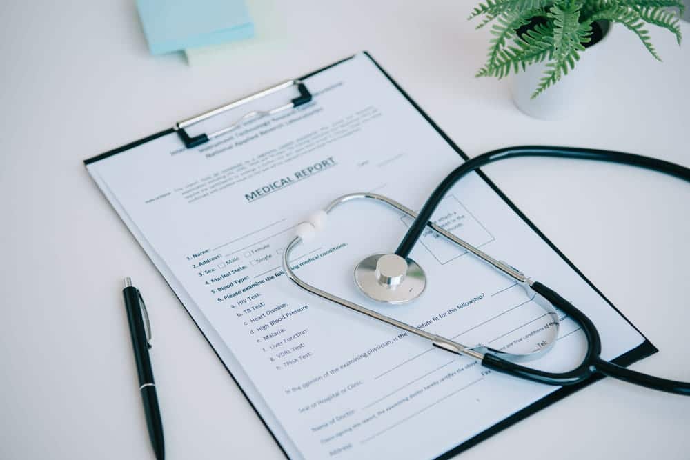 Image is of a medical report with a stethoscope, concept of injury evaluation after a slip and fall at work