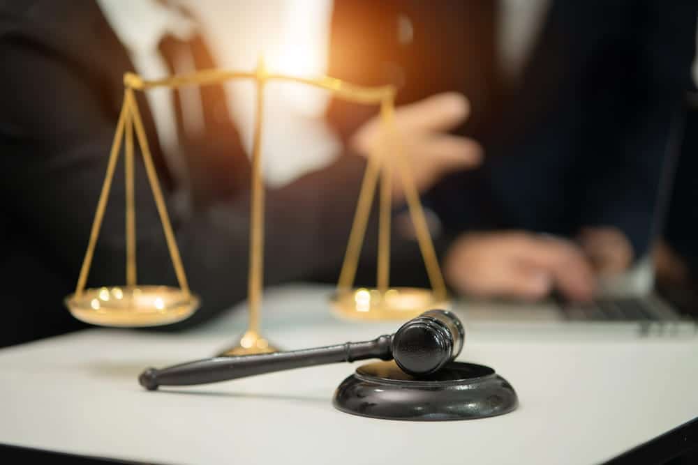 Image is of a gavel and balance scales on a desk during a legal discussion, symbolizing services of a Nashville motorcycle accident lawyer