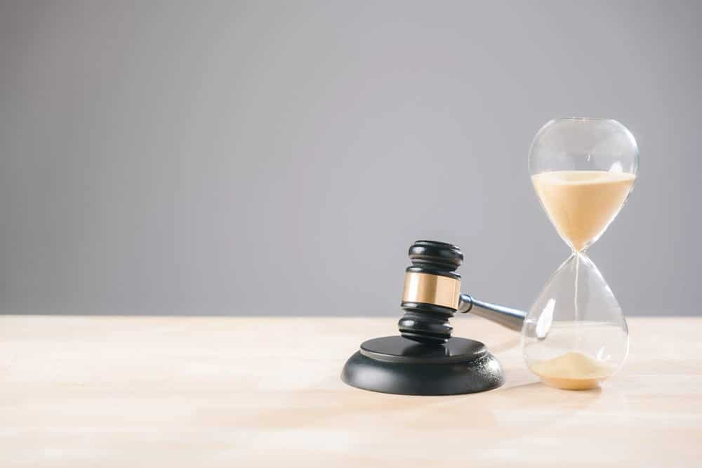 Image is of a gavel beside an hourglass, concept of legal timing when hiring a car accident lawyer in Nashville