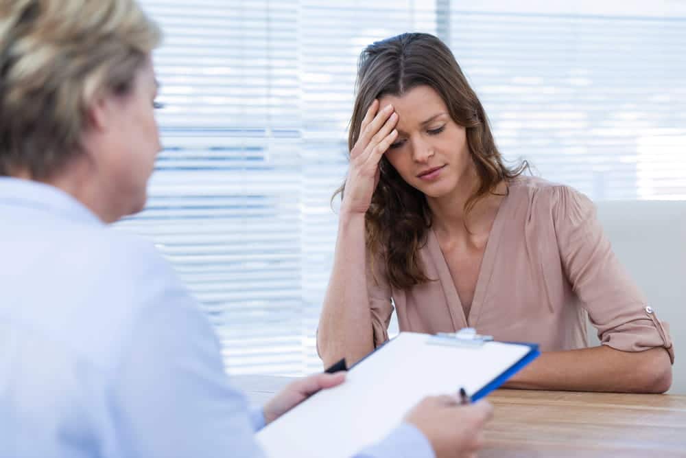 Image is of a woman discussing emotional stress with a counselor after a car accident in Nashville, concept of trauma recovery and emotional distress claims.