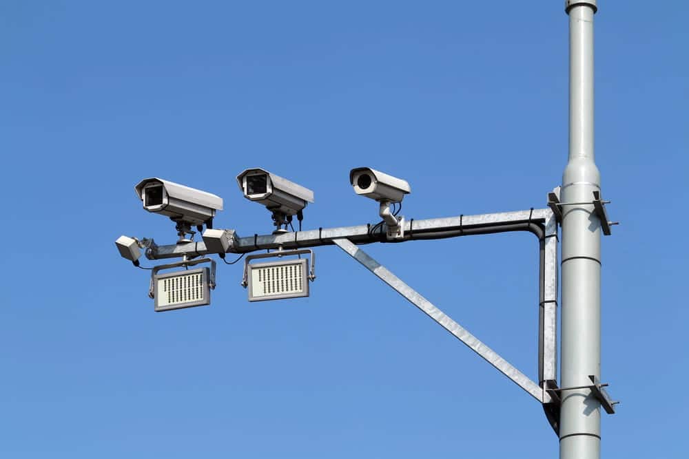 Image is of traffic surveillance cameras mounted above a roadway, concept of collecting evidence after a motorcycle crash.