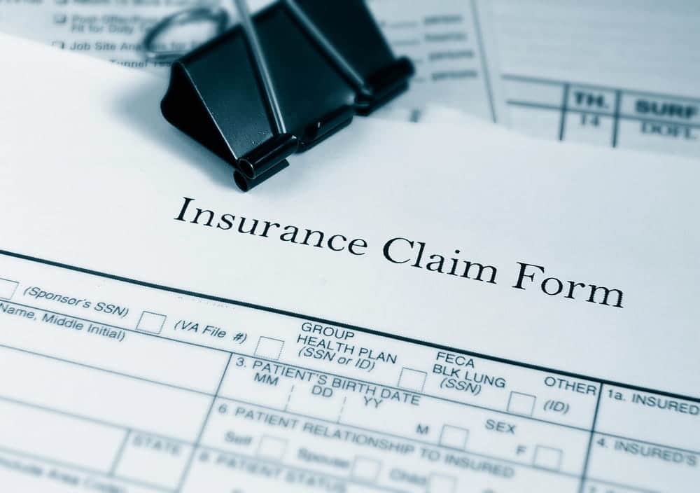 Image is of an insurance claim document on a desk with office paperwork, concept of filing compensation claims after a Nashville truck accident.