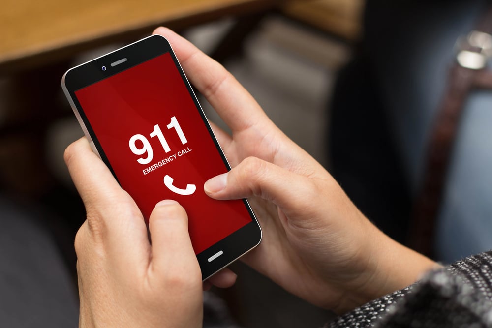 Image is of a person using a mobile phone to contact emergency services, concept of seeking immediate assistance after a DUI motorcycle accident.