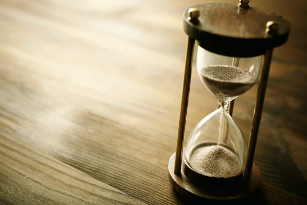 Image is of an hourglass on a wooden table, concept of time limits for a slip and fall claim in Tennessee