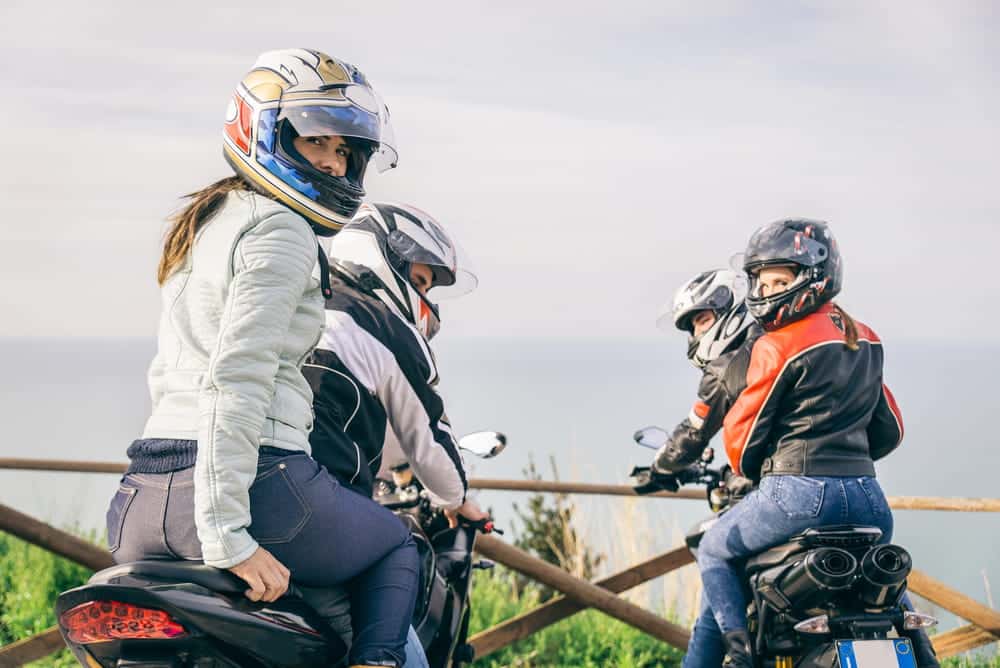 Image is of several motorcycle riders and passengers wearing protective helmets during a group ride, concept of passenger safety after a motorcycle crash in Nashville.