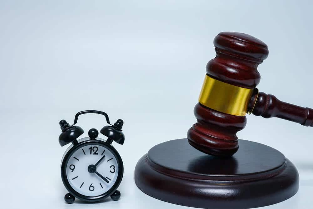 Image is of a judge's gavel placed beside a clock, concept of truck accident claim