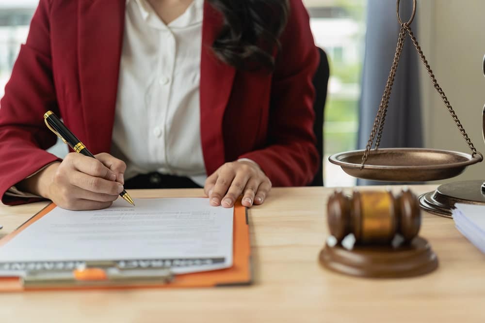 Image is of an attorney reviewing and signing legal documents, concept of a truck accident lawsuit in Nashville and the legal process.