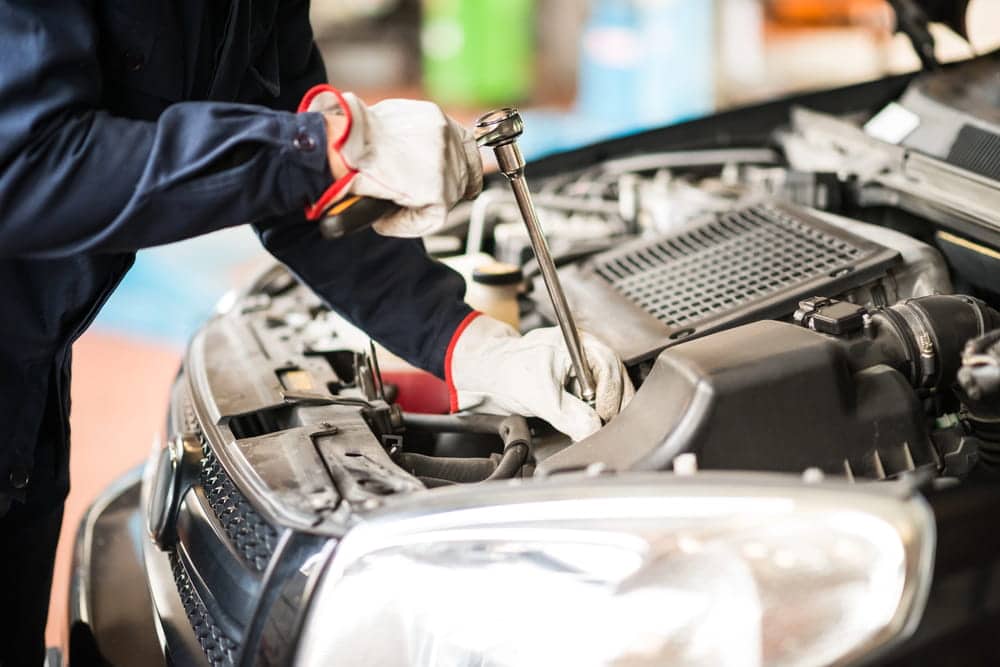 Image is of a mechanic inspecting a vehicle engine during repairs, concept of car accidents in Nashville related to mechanical defects.