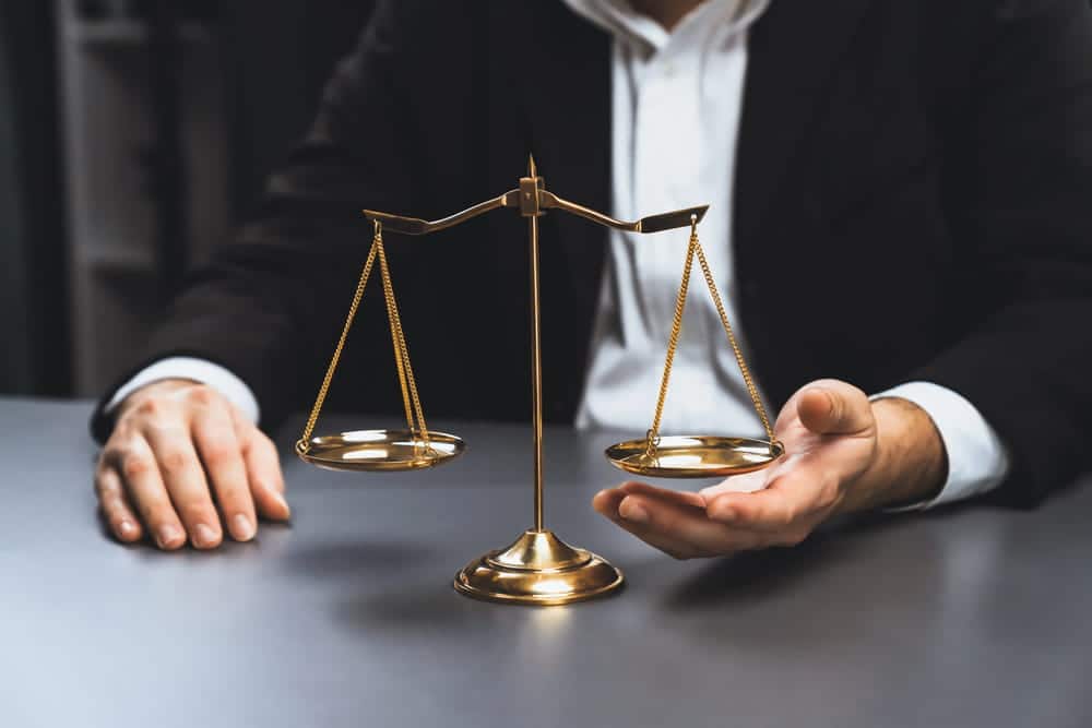 Image is of a person holding scales of justice, concept of slip and fall claims.