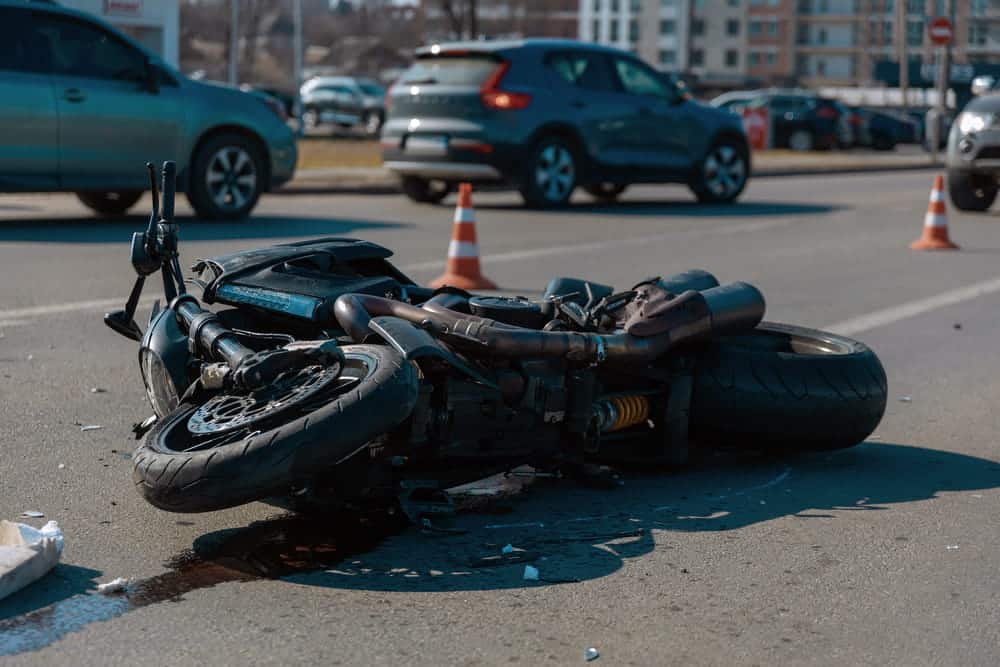 Image is of a damaged motorcycle at a crash scene, concept of comparative fault in a Nashville motorcycle claim