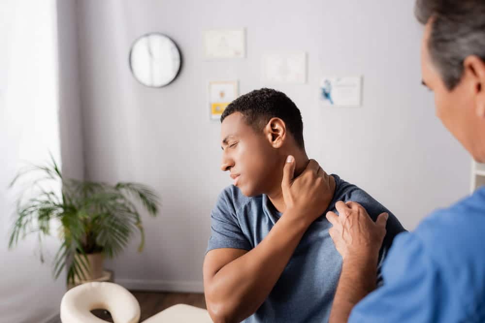 Image is of a patient receiving a medical examination for neck pain, concept of motorcycle crash in Nashville and delayed injury symptoms.