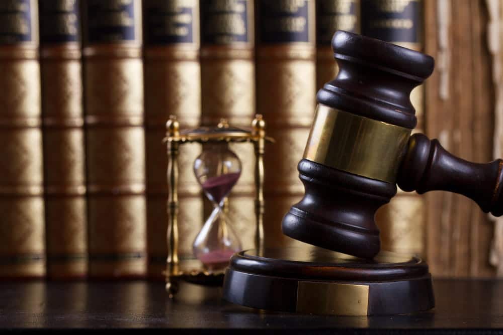 Image is of a judge's gavel with an hourglass and law books, concept of the deadline to file a dog bite claim in Tennessee.