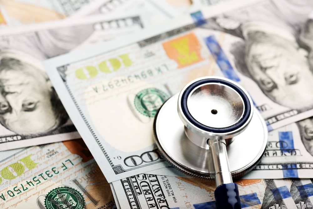 Image is of a stethoscope placed on U.S. currency, concept of medical costs after a slip and fall in Nashville.