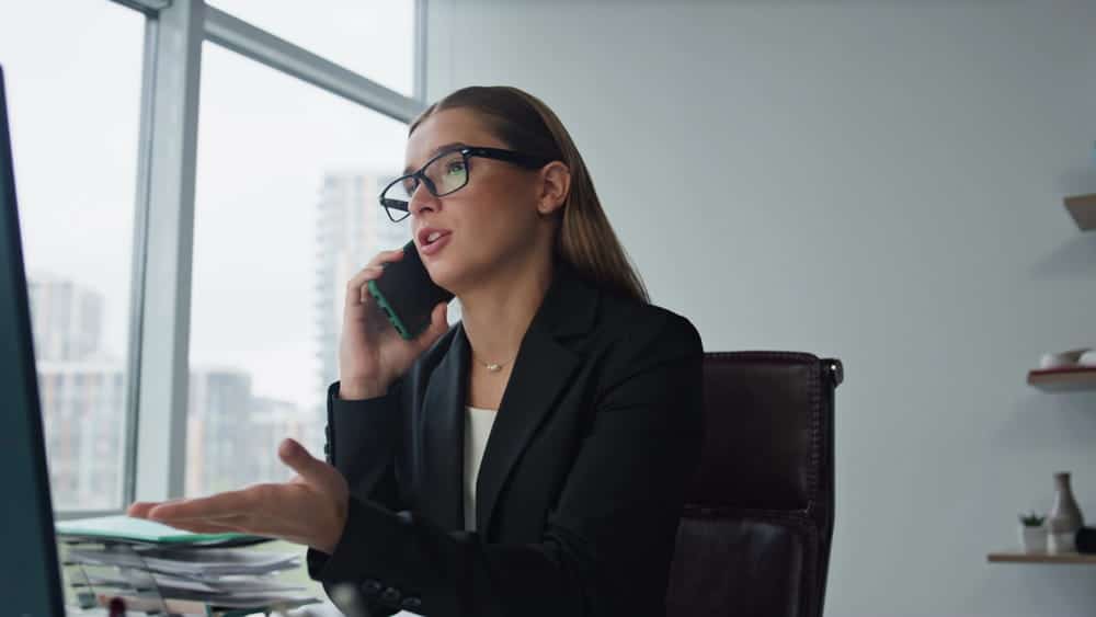 Image is of a woman speaking on the phone, concept of giving a recorded statement for a car accident claim.