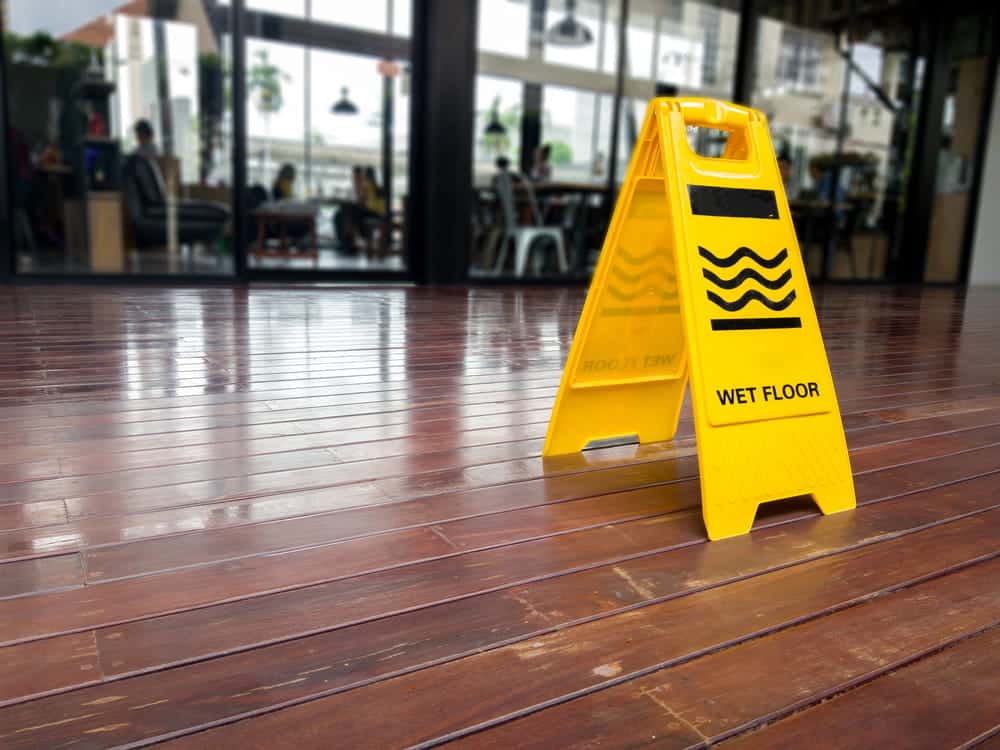 Image is of a wet floor warning sign inside a hotel, representing a potential hazard involved in a slip and fall accident.