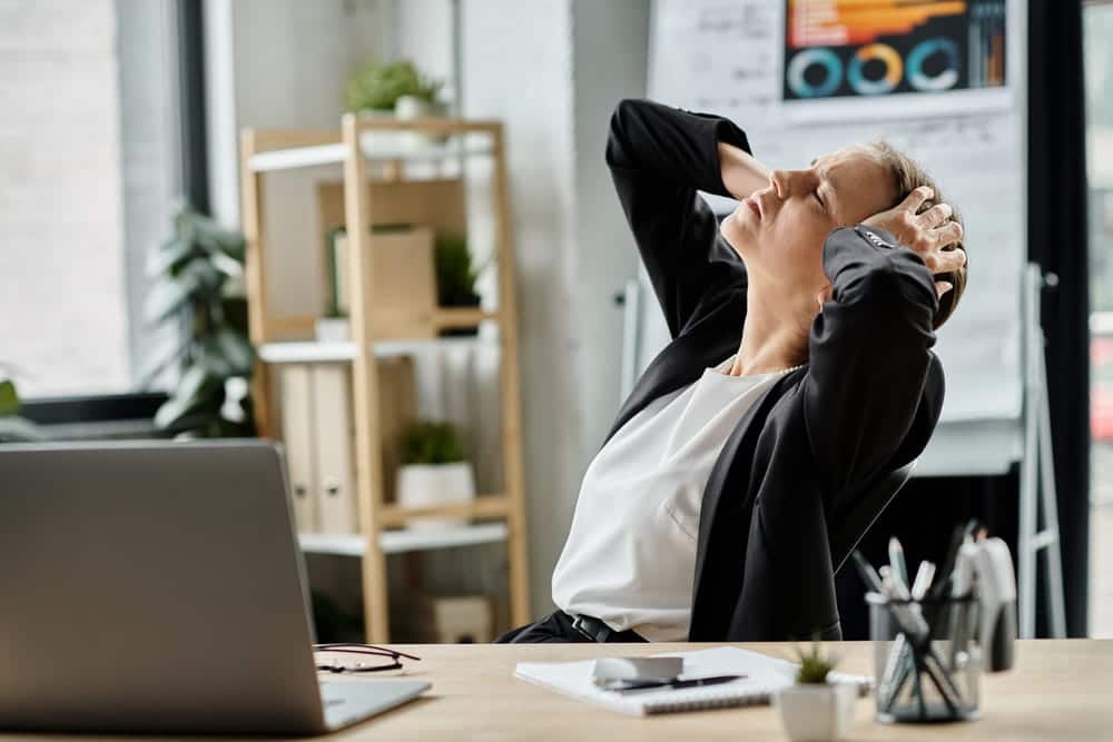 Image is of a concerned woman sitting at her desk, concept of challenges involved in proving a slip and fall claim.