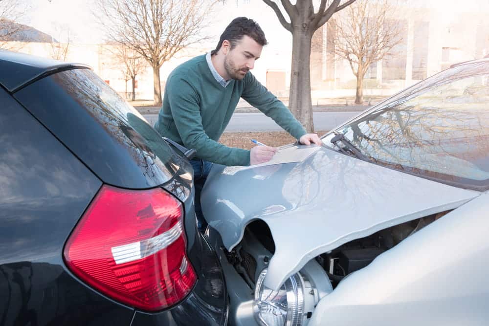 Image is of a driver exchanging information after a multi vehicle collision, representing a car accident in Nashville.