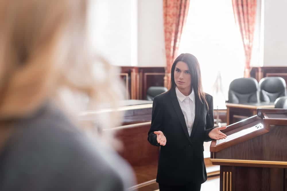 Image shows a female lawyer speaking in a courtroom, illustrating how witness statements and testimony can provide evidence in a slip and fall case.