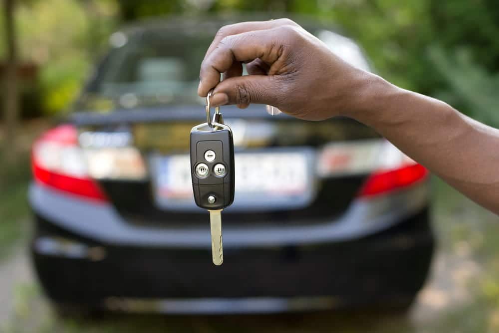 Image is of a person holding car keys in front of a vehicle, concept of rental car accident in Nashville and rental vehicle responsibilities.